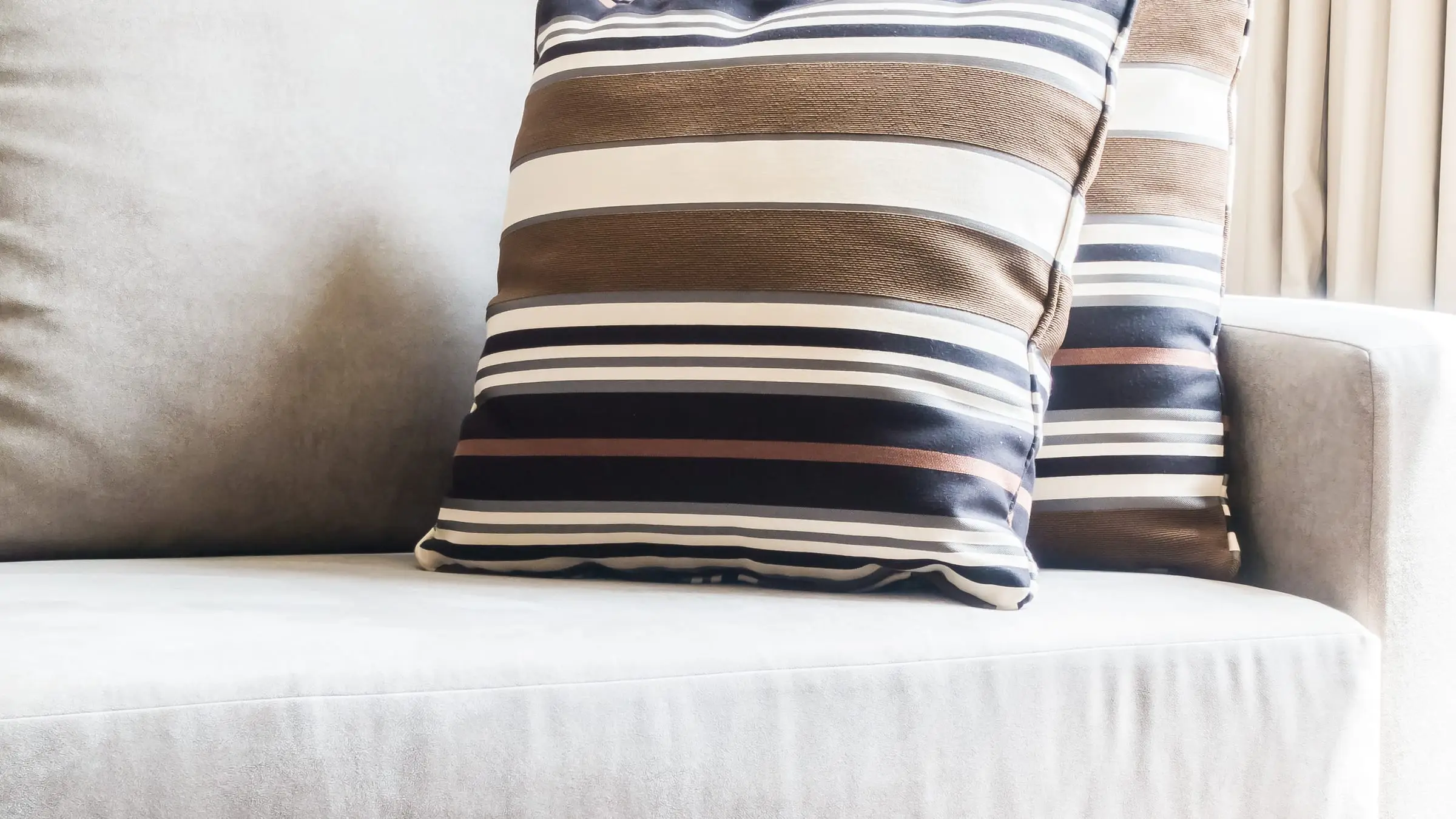 Jasna tapicerowana sofa z poduszkami